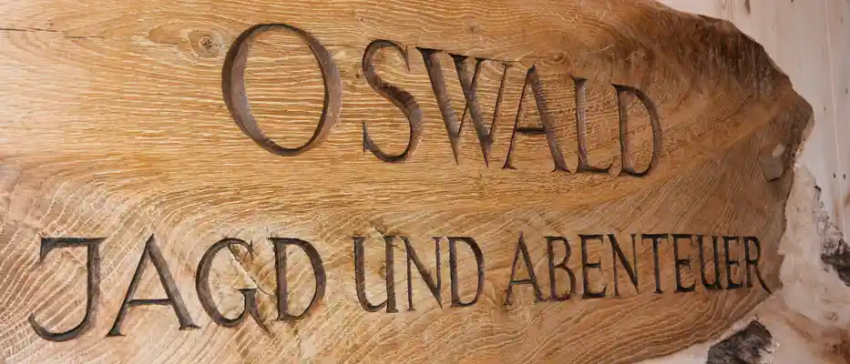Holztafel aus einem Baumstamm mit Gravur, Oswald Jagd und Abenteuer.